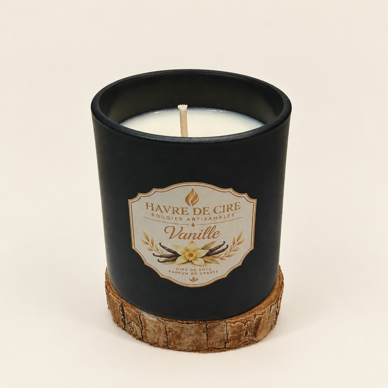 Bougie Havre de Cire Vanille en cire de soja, pot en verre noir mat posé sur un rondin de bois, sur fond crème